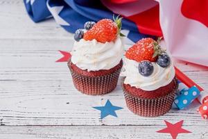 dolce cupcakes con mirtilli e fragola , Stati Uniti d'America bandiera su blu sfondo foto