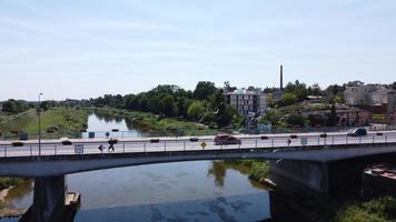 ponte al di sopra di il fiume. veicoli equitazione su il ponte al di sopra di il fiume nel il mezzo di il città. pedoni su il ponte. Visualizza a partire dal drone. foto