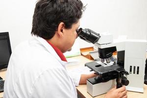 patologo Lavorando con macchiato fazzoletto di carta biopsia su bicchiere scivoli nel il laboratorio. cancro diagnosi concetto. medico concetto. foto