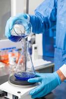 giovane maschio scienziato Lavorando con un agitatore a laboratorio vestito nel blu foto