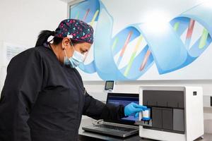 femmina scienziato Lavorando a il laboratorio con un' termico ciclista. polimerasi catena reazione tecnica. pcr tecnica foto