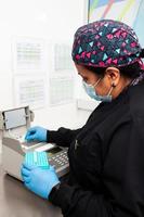 femmina scienziato Lavorando a il laboratorio con un' termico ciclista. polimerasi catena reazione tecnica. pcr tecnica foto