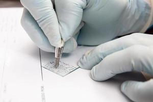 laboratorista etichettatura un' microscopio diapositiva utilizzando un' diamante mancia matita. laboratorista dando ammissione per pap sbavatura campioni nel il laboratorio per analisi. foto