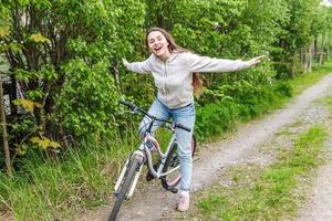 giovane donna equitazione bicicletta nel estate città parco all'aperto. attivo le persone. fricchettone ragazza rilassare e ciclista bicicletta foto