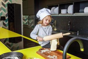 poco ragazza preparazione Impasto, infornare fatti in casa vacanza Mela torta nel cucina foto