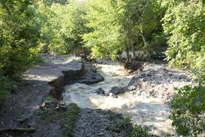 un' naturale disastro di allagamento, fangoso flussi di acqua con pietre e fango nel il strade di il città. foto