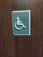 Disabilitato gabinetto porta segno, sedia a rotelle simbolo gabinetto segno, handicap bagno cartello foto