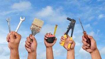 mani Tenere diverso carpenteria utensili contro blu cielo sfondo. lavoro duro e faticoso giorno concetto foto