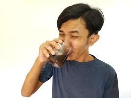 asiatico uomo bevanda un' tiro di amaro caffè espresso caffè foto
