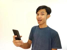Wow e sorpresa viso asiatico uomo uso smartphone con copia spazio di annuncio pubblicitario foto