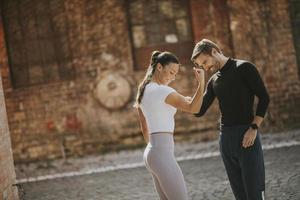 giovane donna facendo esercizio di stretching dopo aver fatto jogging con il suo personal trainer foto