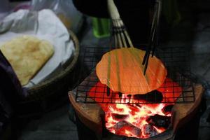 indigeno riso cracker su stufa su strada cibo notte mercato a Tailandia foto