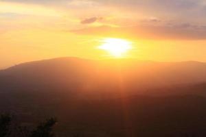 bellissimo paesaggio strati di montagna e nebbioso su collina valle nel d'oro crepuscolo di tramonto a Tailandia foto