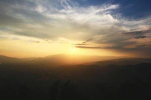 bellissimo paesaggio strati di montagna e nebbioso su collina valle nel d'oro crepuscolo di tramonto a Tailandia foto