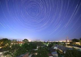 sentieri di stelle nel notte cielo sopra città foto