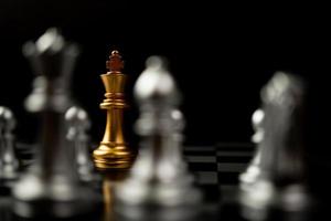 scacchi del re d'oro in piedi di fronte ad altri scacchi, il concetto di un leader deve avere coraggio e sfida nella competizione, leadership e visione aziendale per una vittoria nei giochi d'affari foto