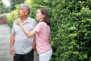 un vecchio anziano asiatico uomo e a piedi nel il Giardino dietro la casa con sua figlia. concetto di contento la pensione con cura a partire dal un' badante e risparmi e anziano Salute assicurazione foto