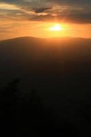 bellissimo paesaggio strati di montagna e nebbioso su collina valle nel d'oro crepuscolo di tramonto a Tailandia foto