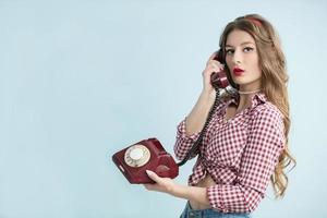 donna nel il stile di il anni cinquanta. giovane retrò donna con un vecchio telefono. foto