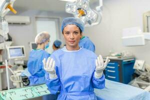 ritratto di contento donna chirurgo in piedi nel operativo camera, pronto per opera su un' paziente. femmina medico lavoratore nel chirurgico uniforme nel operazione Teatro. foto