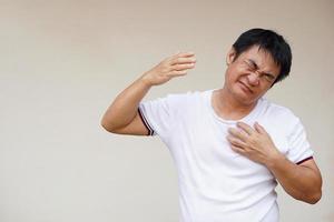 asiatico uomo si sente piccante, scomodo, infelice con caldo tempo metereologico soffocante condizione quello può causa colpo di calore, malato o malattia. concetto, globale riscaldamento effetto con Salute foto