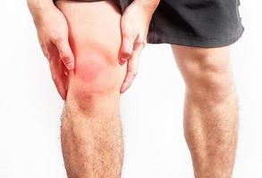 asiatico maschio ginocchio Tenere il suo doloroso causato di esercizio. asiatico uomo mano Tenere il suo dolore ginocchio bianca isolato sfondo foto