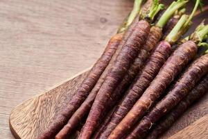 carota bambino viola su legna tavolo cucina sfondo foto