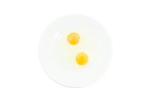 crudo uovo tuorli nel un' bianca ciotola isolato su bianca sfondo, per preparare per un' alto proteina dieta ha aiutato nel il crescita di un' di persona corpo foto