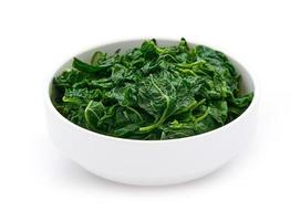 mucchio di verde cucinare foglia spinaci nel bianca ciotola isolato su bianca sfondo. le foglie spinaci o mucchio di spinaci isolato foto