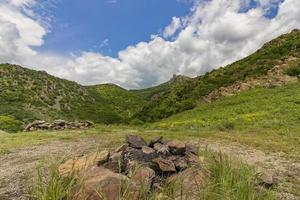 spettacolare Visualizza di colline di un' montagna gamma. abbandonato camino campeggio sotto blu cielo foto