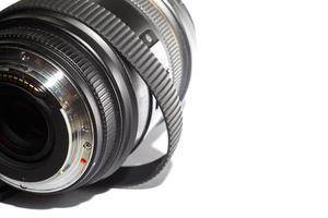Obiettivo fotografico reflex con anello in gomma allungato nel tempo isolato su sfondo bianco foto