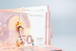 persone in miniatura, scalatore si arrampica su una banconota in euro, concetto di business. foto