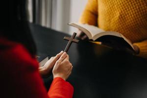 Due persone lettura e studia Bibbia nel casa e pregare insieme.studiando il parola di Dio con gli amici. foto