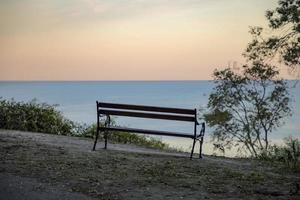 di legno panchina con un' Visualizza a mare e giorno cielo. bellissimo posto per rilassante e godendo natura. in viaggio fermare per i viaggiatori. foto