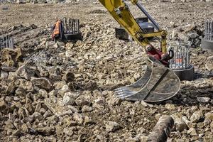 Visualizza di un' parte di singolo scavatrice braccio con idraulico tubi e cilindro a un' costruzione luogo. vicino foto