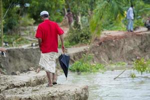 bangladesh giugno 27, 2015 uomo donna e popoli siamo attraversamento fiume erosione influenzato ciglio della strada a rasulpur, barisal quartiere. foto