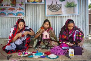 bangladesh Maggio 14, 2018 mestiere villaggio dove artigiane siamo fabbricazione casa e ufficio Usato fiore all'occhiello su ananas foglia fibre e Banana fibra a tanga, bangladesh. foto