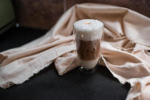 primo piano bicchiere di caffè freddo con latte sul tavolo foto