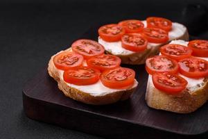 delizioso croccante grigliato crostini con formaggio e ciliegia pomodori foto