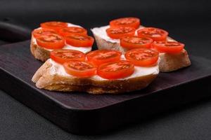 delizioso croccante grigliato crostini con formaggio e ciliegia pomodori foto