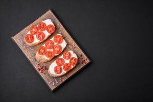 delizioso croccante grigliato crostini con formaggio e ciliegia pomodori foto