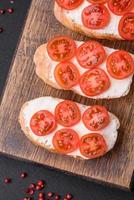 delizioso croccante grigliato crostini con formaggio e ciliegia pomodori foto