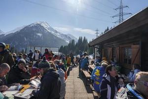 turisti lettura libri e avendo divertimento a sciare ricorrere su soleggiato giorno foto