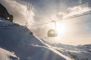 gondola sollevamento al di sopra di bellissimo neve coperto montagne contro luminosa sole foto