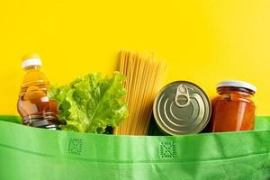 concetto di consegna del cibo su uno sfondo giallo. sacchetto biodegradabile con alimenti essenziali. foto