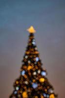 colorato Natale albero scintillante contro il sfondo di il sera pastello cielo foto