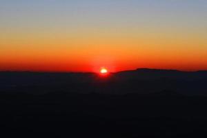 tramonto nel cielo e nube, bellissimo colorato crepuscolo tempo con silhouette di montagna. foto