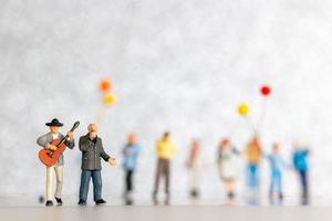 miniatura cantante e musicista giocando un' chitarra su palcoscenico, mondo musica giorno concetto foto