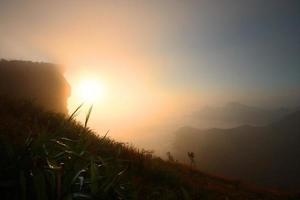 bellissimo silhouette paesaggio valle di montagna con nebbioso e nebbia nel inverno di Alba splendente su il cielo a phu chee fah collina settentrionale di Tailandia foto