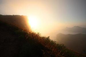 bellissimo silhouette paesaggio valle di montagna con nebbioso e nebbia nel inverno di Alba splendente su il cielo a phu chee fah collina settentrionale di Tailandia foto